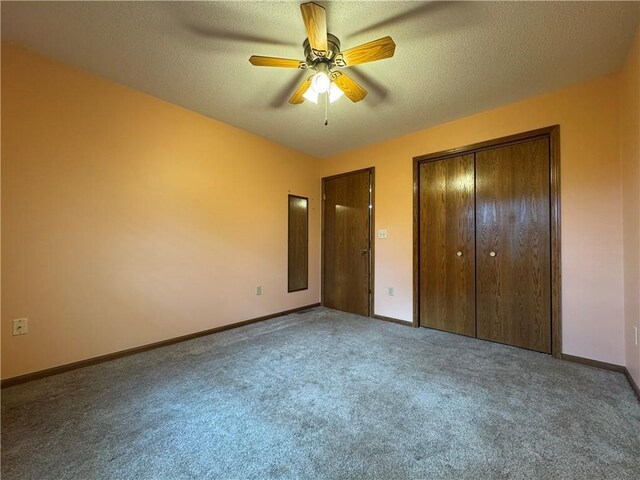 unfurnished bedroom with carpet floors, a textured ceiling, and baseboards