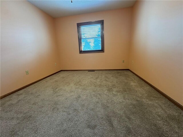 carpeted spare room with baseboards