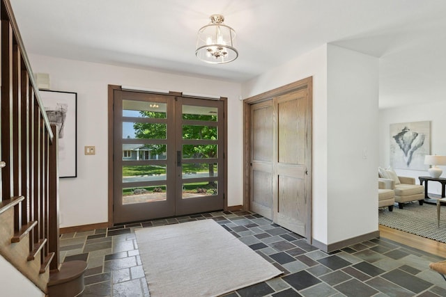 7000 Lanham Ln, Edina, MN 55439 - foyer entrance with a chandelier, stairs, dark stone finish flooring, and french doors