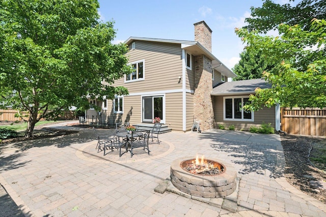 7000 Lanham Ln, Edina, MN 55439 - back of property with a fire pit, a patio area, and a chimney
