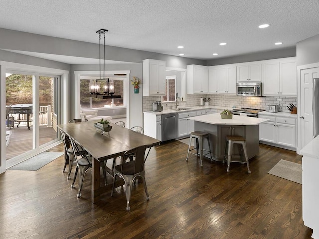 kitchen featuring a sink, backsplash, a kitchen island, and stainless steel appliances