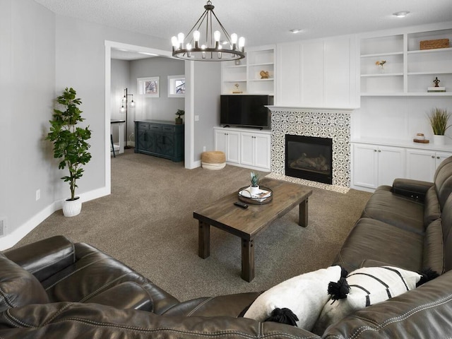 living area featuring visible vents, an inviting chandelier, a fireplace, baseboards, and carpet