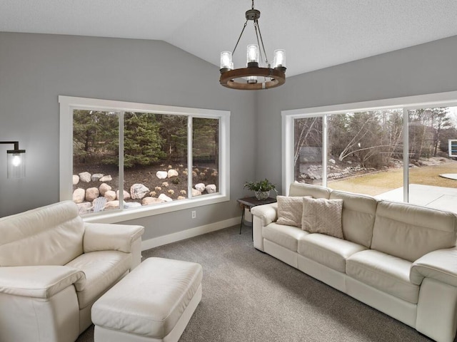 living area featuring baseboards, carpet flooring, a chandelier, and vaulted ceiling