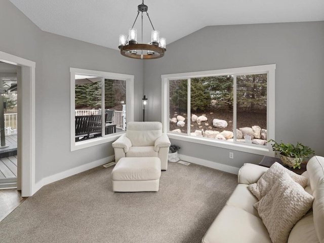 sitting room featuring a healthy amount of sunlight, vaulted ceiling, carpet flooring, and a chandelier