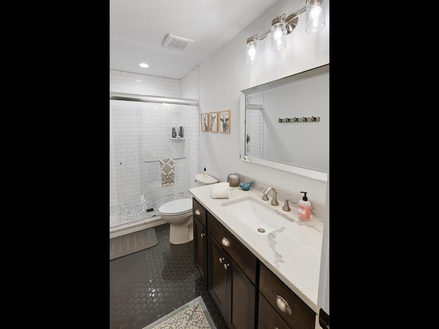 full bath featuring vanity, toilet, tile patterned floors, visible vents, and a stall shower