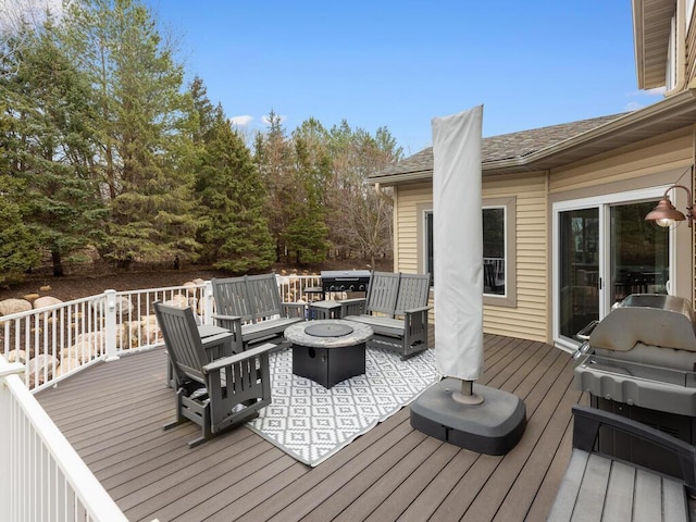 wooden terrace with grilling area and a fire pit