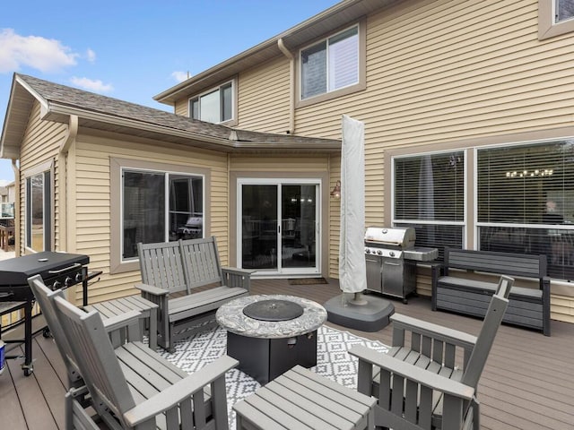 wooden terrace featuring an outdoor living space with a fire pit and area for grilling