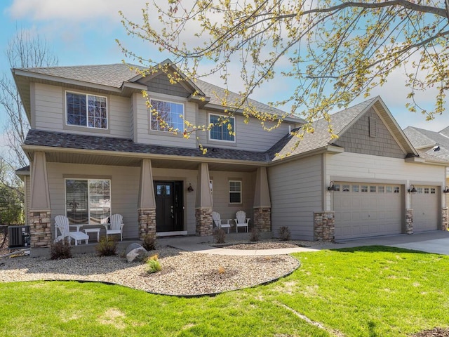 craftsman inspired home with covered porch, a front yard, stone siding, cooling unit, and an attached garage
