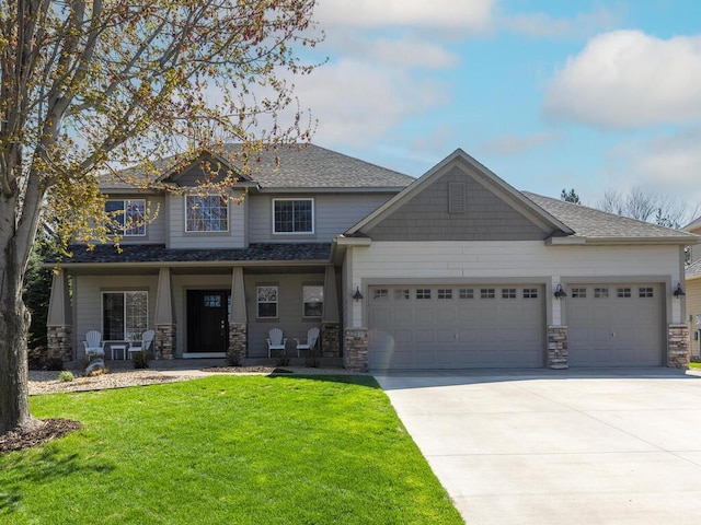 craftsman inspired home featuring a garage, stone siding, a front yard, concrete driveway, and a porch