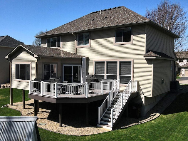 rear view of house featuring a shingled roof and a deck