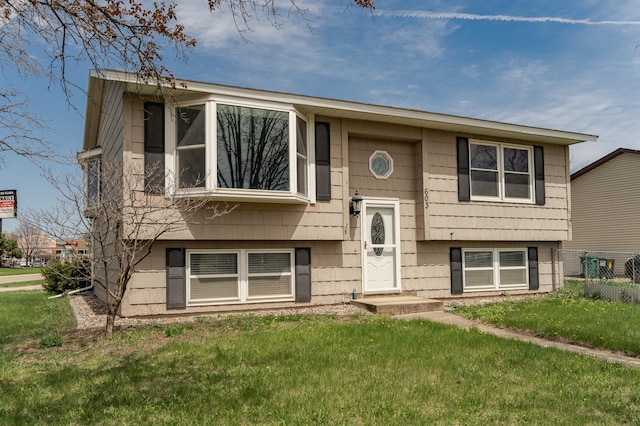 split foyer home featuring fence and a front yard