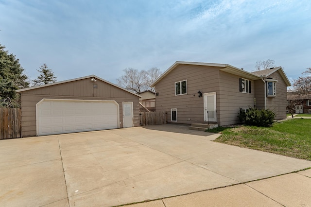 view of front of home featuring a detached garage, fence, and an outbuilding