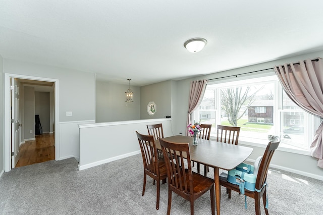 carpeted dining room with baseboards