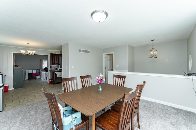 dining space with visible vents, baseboards, and a notable chandelier