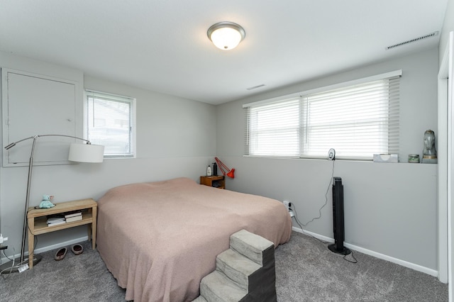 carpeted bedroom featuring visible vents, baseboards, and multiple windows