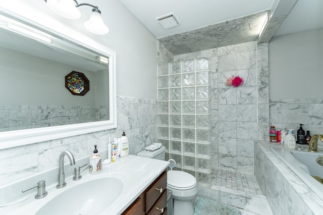 full bath featuring vanity, toilet, tile walls, visible vents, and a garden tub