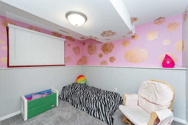 carpeted bedroom with wainscoting and wallpapered walls
