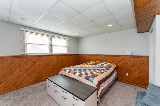 carpeted bedroom featuring wooden walls, a wainscoted wall, recessed lighting, and a paneled ceiling
