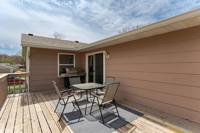 wooden terrace featuring outdoor dining area and grilling area