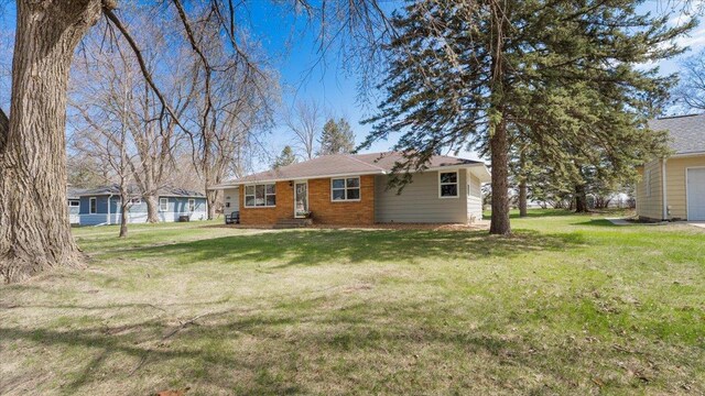 back of property with a garage and a yard
