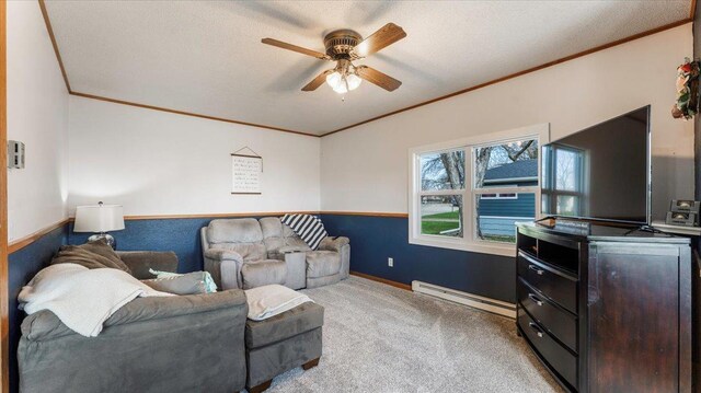 carpeted living area featuring crown molding, a ceiling fan, baseboards, and a baseboard heating unit