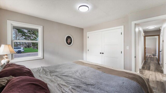 bedroom featuring a closet, a textured ceiling, and wood finished floors