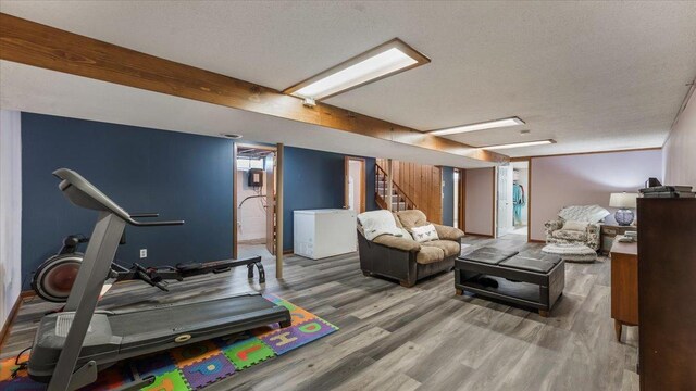 exercise room with a textured ceiling and wood finished floors