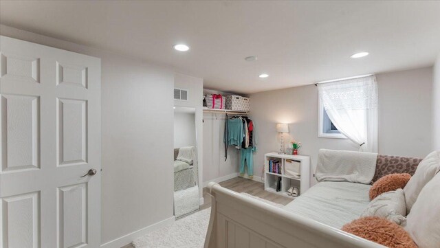 bedroom with baseboards, light colored carpet, recessed lighting, and visible vents