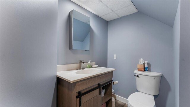 half bath featuring vanity, toilet, and wood finished floors