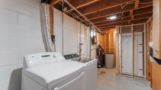 clothes washing area featuring separate washer and dryer and laundry area