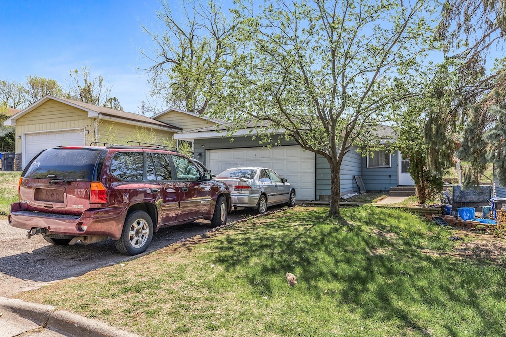 360 Hawthorne Ave E, Saint Paul, MN 55130 - view of front of home with aphalt driveway, an attached garage, and a front lawn