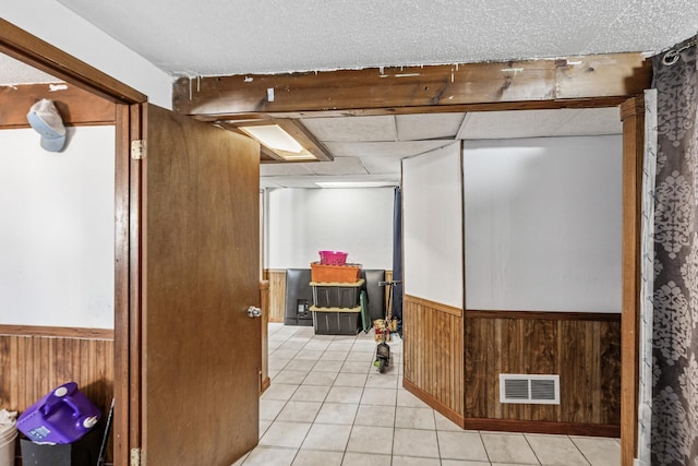 360 Hawthorne Ave E, Saint Paul, MN 55130 - finished below grade area featuring tile patterned floors, a wainscoted wall, visible vents, and wooden walls