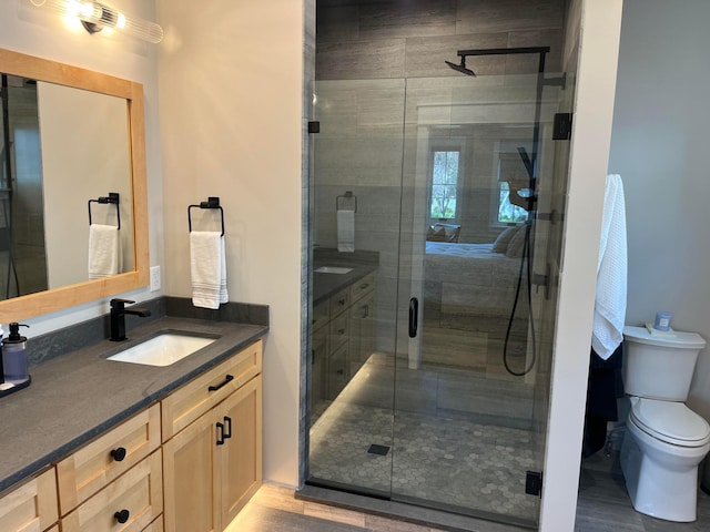 full bath featuring vanity, toilet, a stall shower, and wood finished floors