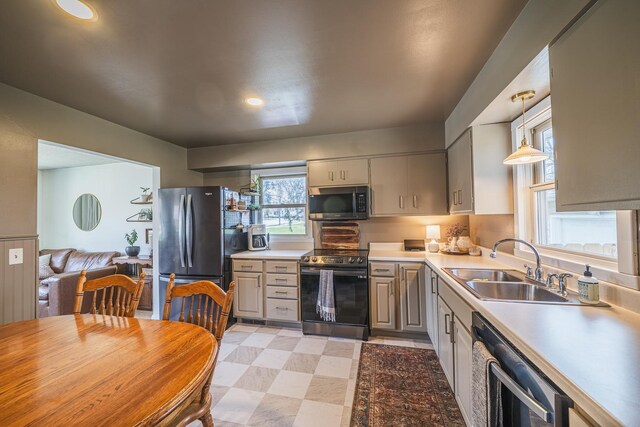 kitchen with a sink, light countertops, gray cabinetry, and stainless steel appliances