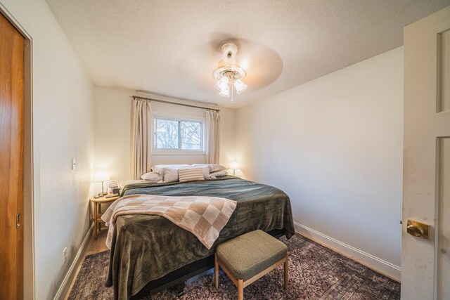 bedroom featuring a textured ceiling, baseboards, and ceiling fan