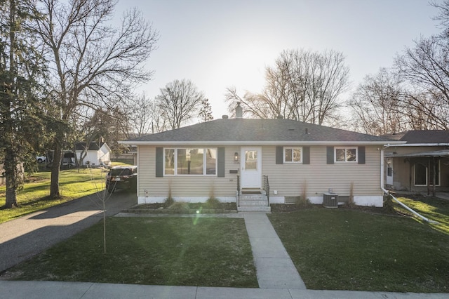 view of front of house with entry steps, central AC unit, and a front lawn