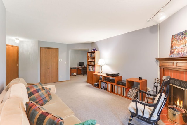 carpeted living room featuring rail lighting, baseboards, and a fireplace