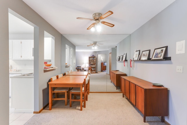 dining area with ceiling fan, light carpet, and baseboards