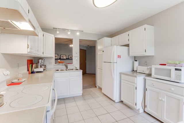 kitchen with track lighting, white appliances, white cabinetry, under cabinet range hood, and a sink