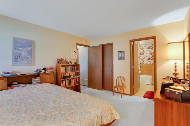bedroom with ensuite bathroom, light carpet, a closet, and visible vents