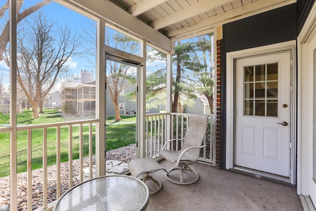 unfurnished sunroom with a residential view and beamed ceiling