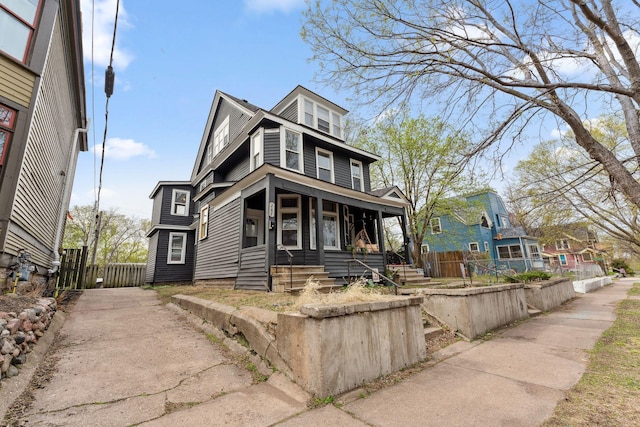 traditional style home with covered porch, fence, and driveway