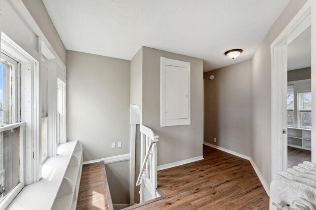 interior space featuring baseboards, an upstairs landing, and wood finished floors