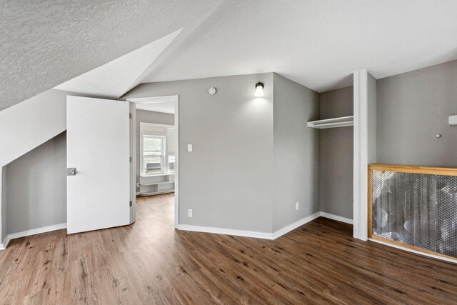 bonus room with baseboards and wood finished floors