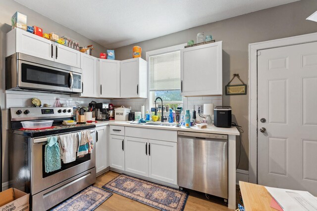 kitchen featuring a sink, light countertops, backsplash, and stainless steel appliances
