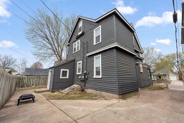 back of property featuring fence and a patio