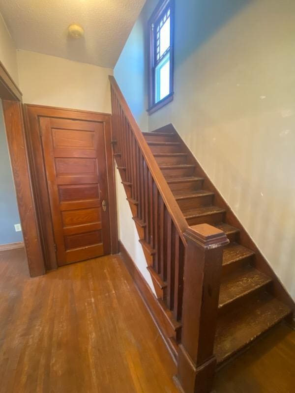 528 Broadway St, Spring Valley, MN 55975 - staircase with a textured ceiling and wood finished floors