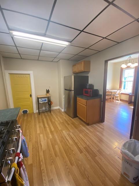 528 Broadway St, Spring Valley, MN 55975 - kitchen with a paneled ceiling, dark countertops, light wood finished floors, and appliances with stainless steel finishes