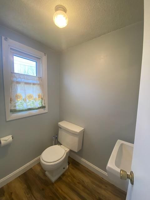 528 Broadway St, Spring Valley, MN 55975 - bathroom featuring toilet, baseboards, a textured ceiling, and wood finished floors