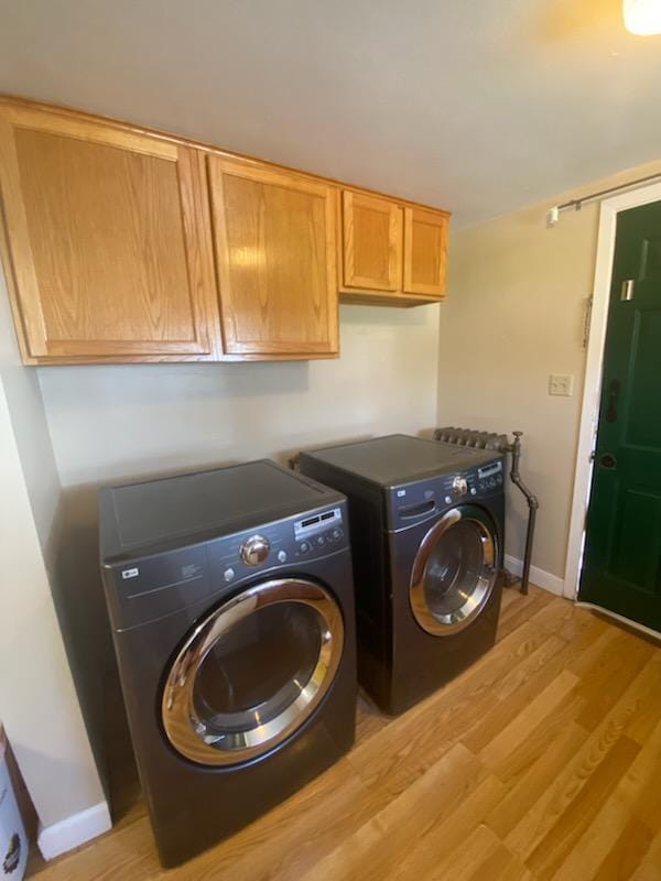 528 Broadway St, Spring Valley, MN 55975 - laundry room featuring washing machine and clothes dryer, baseboards, light wood finished floors, and cabinet space